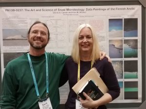 A man and a woman in front of a poster at a science conference